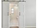 A view of the en suite bathroom through sliding barn doors featuring a marble vanity at 94 Nicholas Dr, Dunedin, FL 34698
