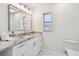 Stylish bathroom featuring a granite vanity, square mirror and a frosted window at 94 Nicholas Dr, Dunedin, FL 34698