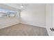 The empty carpeted bedroom features a window with light coming through and a ceiling fan at 94 Nicholas Dr, Dunedin, FL 34698
