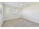 A bright bedroom with new carpet, ceiling fan and a sunlit window at 94 Nicholas Dr, Dunedin, FL 34698