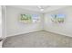 A bright bedroom with new carpet, ceiling fan, and dual windows at 94 Nicholas Dr, Dunedin, FL 34698