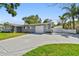 Expansive concrete driveway leading to an attached garage, complemented by a well-maintained lawn and landscaping at 94 Nicholas Dr, Dunedin, FL 34698