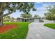 Beautiful single-story home with a large tree, green lawn, well-maintained landscaping, and spacious driveway at 94 Nicholas Dr, Dunedin, FL 34698