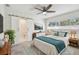 Comfortable main bedroom featuring a ceiling fan, with attached bath with modern sliding barn door at 94 Nicholas Dr, Dunedin, FL 34698
