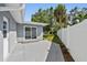 Back patio with sliding glass door, a privacy fence, and a neatly landscaped yard at 94 Nicholas Dr, Dunedin, FL 34698