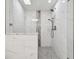 An elegant shower with white marble-style tile and hexagon tile floor at 94 Nicholas Dr, Dunedin, FL 34698