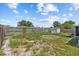 Backyard area features grass, fencing and small storage shed in natural sunlight at 9915 Aetna Ln, Port Richey, FL 34668