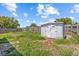 View of backyard area features a small storage shed and wood fencing at 9915 Aetna Ln, Port Richey, FL 34668