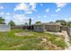 View of the backyard with mature landscaping, a shed, and an enclosed patio space at 9915 Aetna Ln, Port Richey, FL 34668