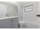 Clean bathroom features a tub, shower, and a sleek gray vanity cabinet at 9915 Aetna Ln, Port Richey, FL 34668