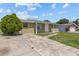 Single-story home with a well-worn driveway and a tidy, green front yard at 9915 Aetna Ln, Port Richey, FL 34668