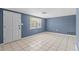 Empty living room features tile floor, fresh paint, and large window at 9915 Aetna Ln, Port Richey, FL 34668