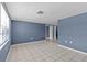 Spacious room featuring neutral tile flooring and freshly painted blue walls at 9915 Aetna Ln, Port Richey, FL 34668
