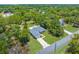 An aerial view of a single-Gathering home surrounded by trees, lush landscaping, and a large, paved driveway at 10197 Meadow Wren Ave, Weeki Wachee, FL 34613