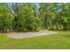Flat gravel pad surrounded by healthy grass, some woods and a black fence at 10197 Meadow Wren Ave, Weeki Wachee, FL 34613