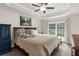 Bright bedroom with large window, ceiling fan, tray ceiling, and en suite bathroom at 10197 Meadow Wren Ave, Weeki Wachee, FL 34613