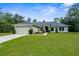 Charming single-story home featuring a well-manicured lawn, beautiful landscaping, and an attached two-car garage at 10197 Meadow Wren Ave, Weeki Wachee, FL 34613
