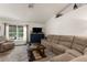 Spacious living room showcasing comfortable seating, a stylish cabinet, and natural light from the large window at 10197 Meadow Wren Ave, Weeki Wachee, FL 34613