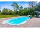 Relaxing backyard pool with water feature, stone patio, and green landscaping for privacy at 10197 Meadow Wren Ave, Weeki Wachee, FL 34613