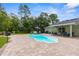 Outdoor pool area with a clear pool, patio seating, and well-manicured landscaping, ideal for relaxation at 10197 Meadow Wren Ave, Weeki Wachee, FL 34613