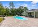 Outdoor pool area with a clear pool, patio seating, and well-manicured landscaping, ideal for relaxation at 10197 Meadow Wren Ave, Weeki Wachee, FL 34613