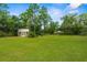 Expansive backyard featuring lush greenery and a storage shed, providing ample space for outdoor activities at 10197 Meadow Wren Ave, Weeki Wachee, FL 34613