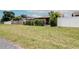 Backyard with lush lawn surrounded by fences, and a covered patio at the rear of the property at 10325 Parkcrest Dr, Tampa, FL 33624