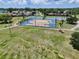 Aerial view of pristine basketball and tennis courts in the neighborhood park providing activities for residents at 10325 Parkcrest Dr, Tampa, FL 33624