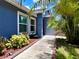 Charming front entrance with lush landscaping and a tiled walkway leading to a cozy home at 10325 Parkcrest Dr, Tampa, FL 33624