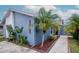 Inviting blue house features manicured landscape with lush greenery and decorative rock accents at 10325 Parkcrest Dr, Tampa, FL 33624