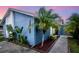 Charming blue house featuring a well-maintained landscape with tropical plants and decorative rock at 10325 Parkcrest Dr, Tampa, FL 33624