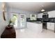 Modern kitchen features white cabinets, stainless steel appliances, and island, with sliding door access to backyard at 10325 Parkcrest Dr, Tampa, FL 33624