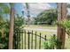 A scenic view of neighborhood homes and tall palm trees, as seen through a decorative black metal gate at 10325 Parkcrest Dr, Tampa, FL 33624