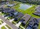 Aerial view showcasing a neighborhood, pond, and homes with well-maintained yards and neighborhood streets at 10464 Tranquil Meadow Loop, Riverview, FL 33569