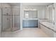 Bright bathroom featuring a walk-in shower, a double vanity, and a soaking tub with stylish tile accents at 10464 Tranquil Meadow Loop, Riverview, FL 33569