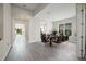 Elegant dining room with wood-look tile, modern table and chairs, and ample natural light at 10464 Tranquil Meadow Loop, Riverview, FL 33569