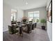 Stylish dining room with a modern black table, comfortable seating, and view into kitchen at 10464 Tranquil Meadow Loop, Riverview, FL 33569