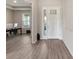 Bright entryway showcasing stylish wood-look tile flooring, leading to a versatile office space at 10464 Tranquil Meadow Loop, Riverview, FL 33569
