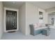 Charming front porch with a cozy wicker sofa and a black front door at 10464 Tranquil Meadow Loop, Riverview, FL 33569