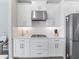 Elegant kitchen with white cabinets, marble countertops, and stainless steel range hood at 10464 Tranquil Meadow Loop, Riverview, FL 33569