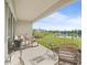 Covered patio with outdoor furniture overlooking a scenic backyard with a tranquil lake view at 10464 Tranquil Meadow Loop, Riverview, FL 33569