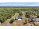 Aerial view of a long driveway leading to a house with a large yard surrounded by trees at 10722 Sumner Rd, Wimauma, FL 33598
