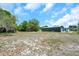 Large backyard with a storage building, grass, and scattered trees on a sunny day at 10722 Sumner Rd, Wimauma, FL 33598