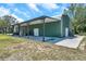 Large green barn featuring covered outdoor storage and a concrete pad at 10722 Sumner Rd, Wimauma, FL 33598