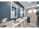 Modern bathroom featuring dual sinks, marble countertops, and a glass-enclosed shower at 10722 Sumner Rd, Wimauma, FL 33598