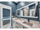 A sleek bathroom showcasing a double sink vanity with white countertops and a large mirror at 10722 Sumner Rd, Wimauma, FL 33598