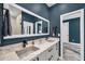 Stylish bathroom featuring dual sinks, white countertops, dark blue walls, and modern fixtures at 10722 Sumner Rd, Wimauma, FL 33598