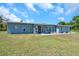 Charming single-story home featuring a modern front door, numerous windows, and manicured landscaping at 10722 Sumner Rd, Wimauma, FL 33598