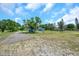 Charming single-story home with a beautiful yard, mature trees, and a long driveway at 10722 Sumner Rd, Wimauma, FL 33598