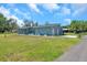 Well-kept single-story home featuring a two-car garage and a sprawling front lawn with mature trees at 10722 Sumner Rd, Wimauma, FL 33598